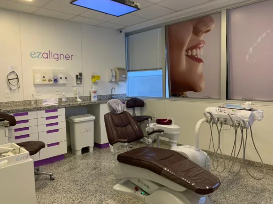consultório da clínica ezaligner com cadeira odontológica e marca na parede